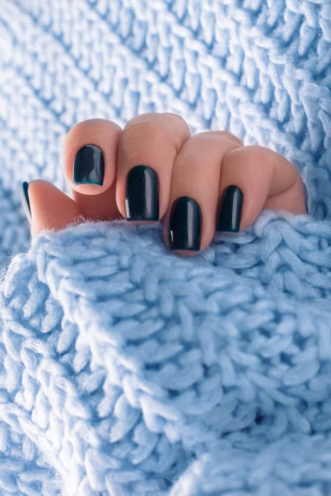 manicura-negra-elegante-moda-sobre-fondo-sueter-azul_mejorada